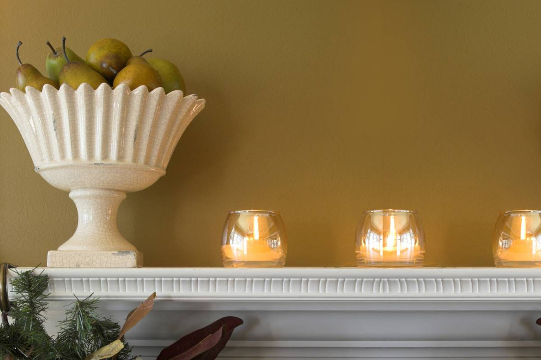 A yellow wall painted with Benjamin Moore paint above a mantel near Detroit, MI